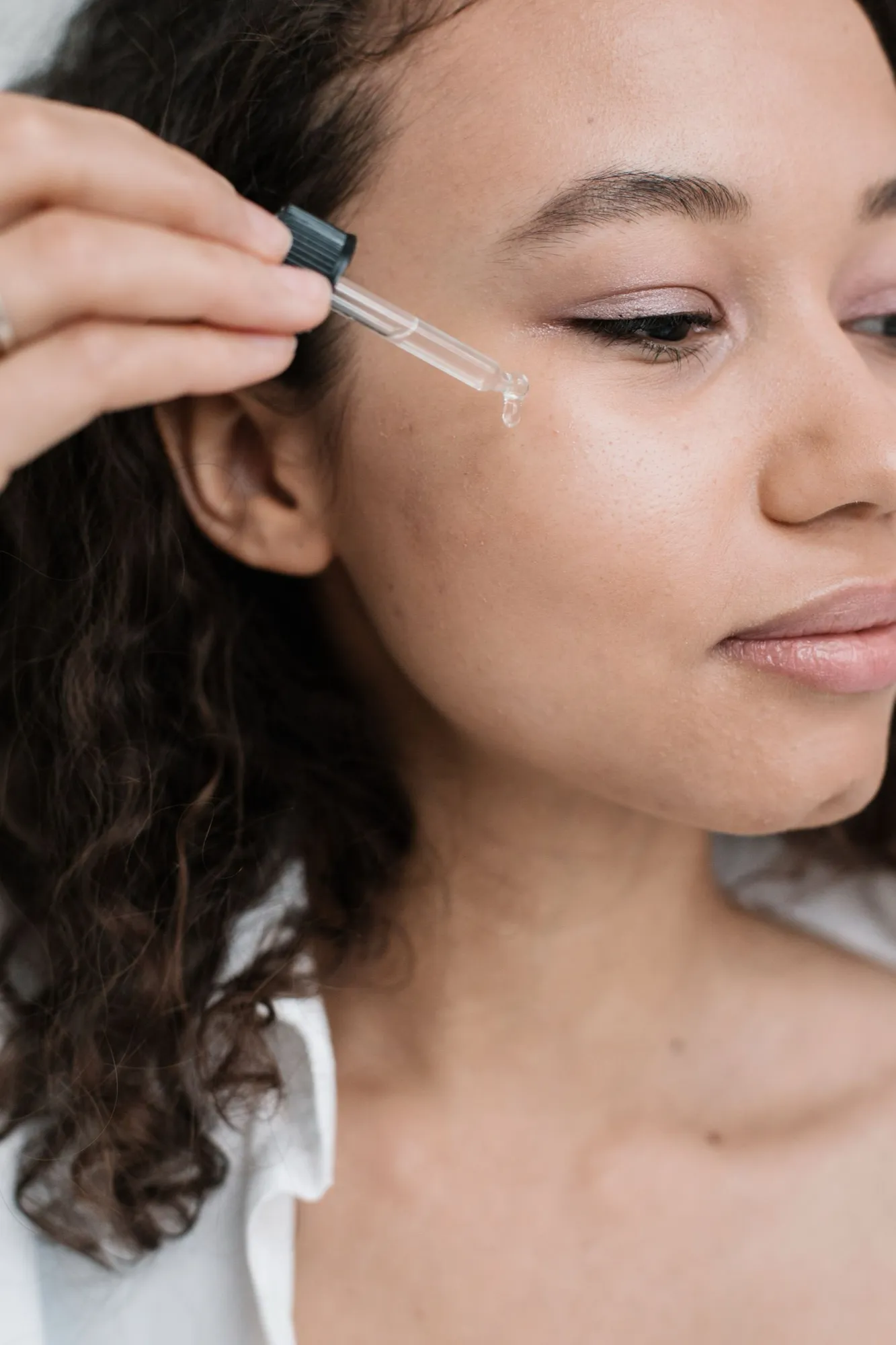 Een vrouw brengt met een pipet serum aan op haar gezicht
